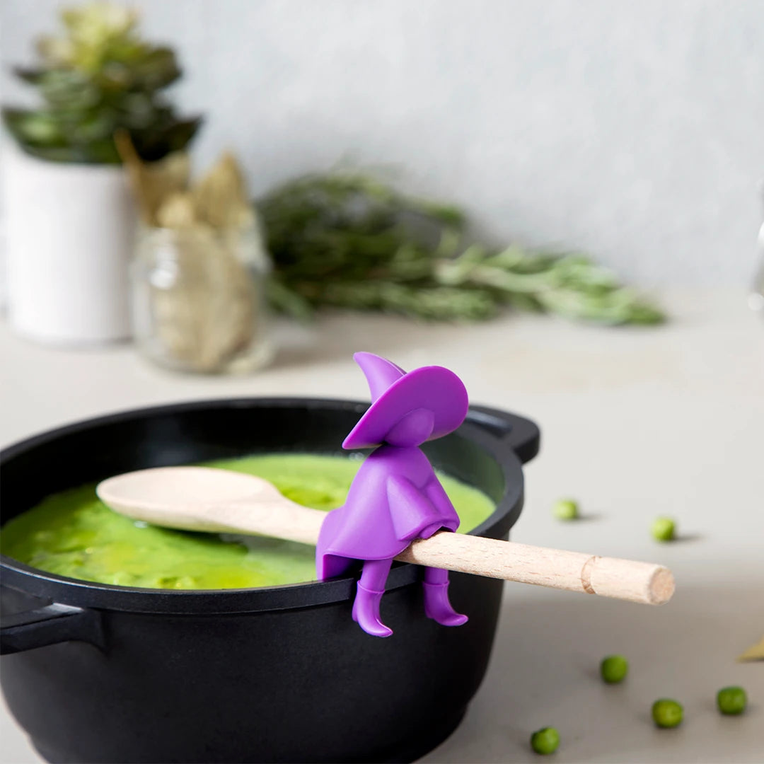 Agatha wizard steam releaser sits on a wooden spoon over green soup.