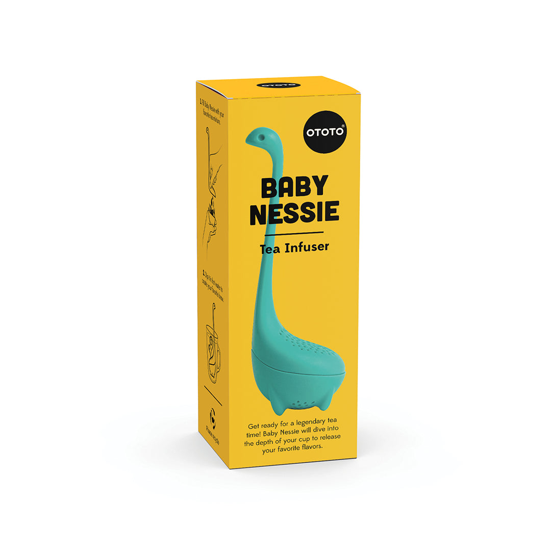 Teal Baby Nessie tea infuser, shaped like the Loch Ness Monster, in a yellow OTOTO Designs box.