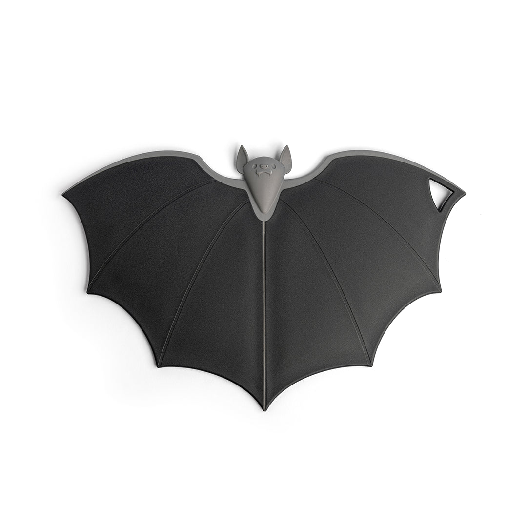 Batty trivet by OTOTO, bat-shaped in dark gray with a hole and folding wings at one wings tip.