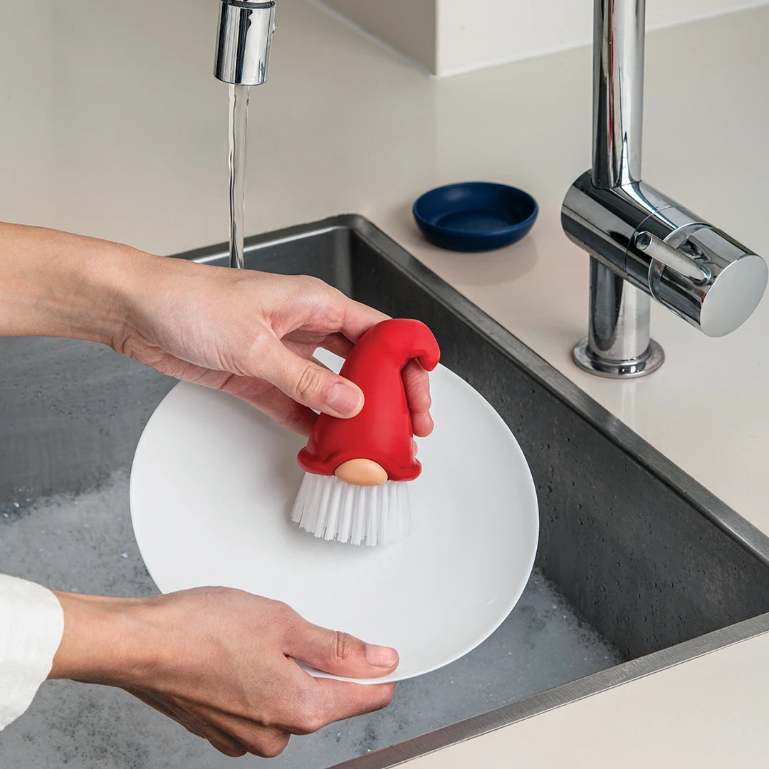 Using Beardy, a gnome dish brush, to wash a plate under running water makes kitchen chores fun with OTOTO.