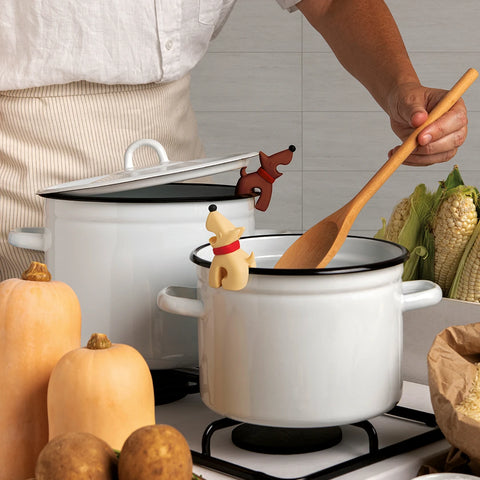 Cooking with OTOTO Best Buddies steam releaser on pots; corn, squash, and cute pot holders around.