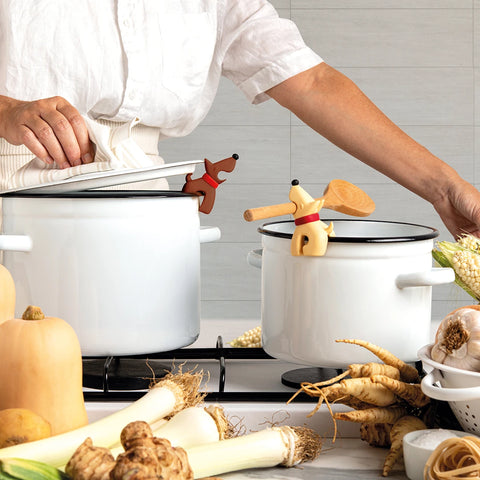 Person cooking with white pots, using OTOTOs Best Buddies utensils and a dial spoon holder. Veggies nearby.