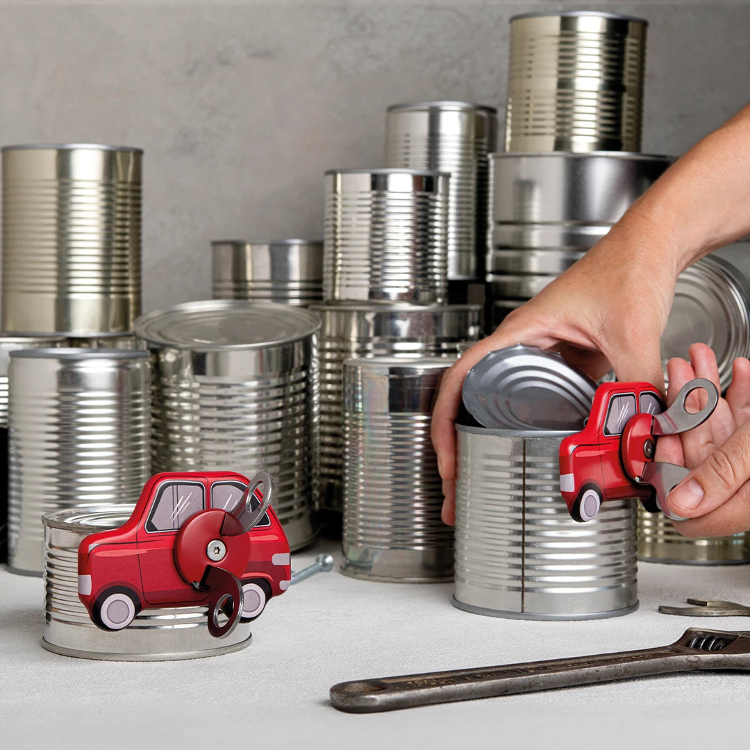 Tin-can toy cars from Can Do, with a hand using a manual opener arranging more in the background.