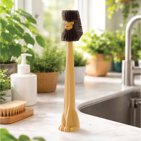 A Cleo bottle cleaner by OTOTO stands upright on the kitchen counter near the sink and plants.