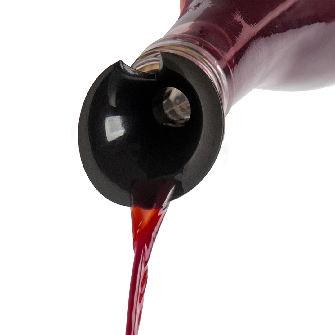 Red liquid pours from a tilted Count Corkula bottle with a black spout on a white background.