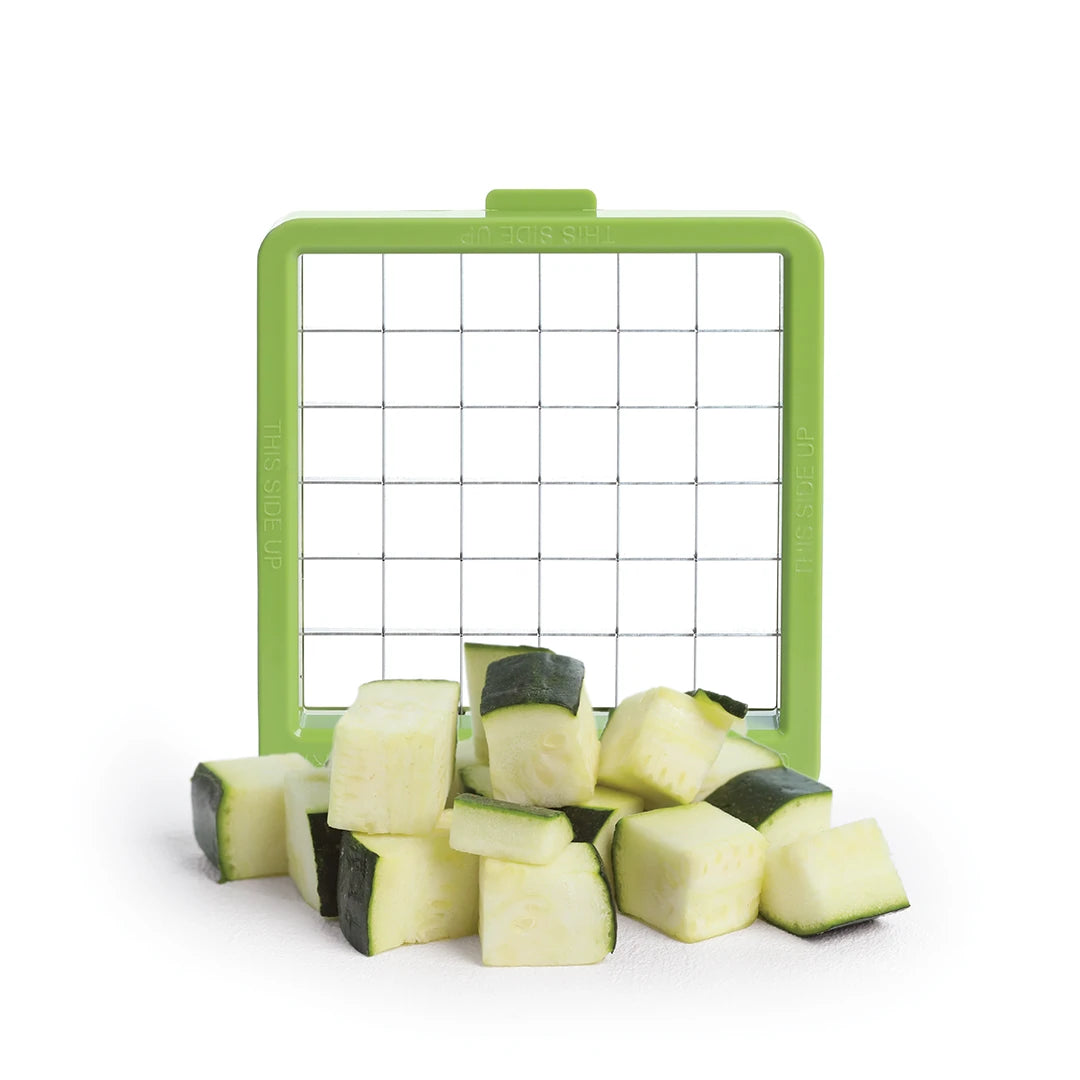 Croc Chop slices zucchini cubes with its interchangeable blades on a white background.
