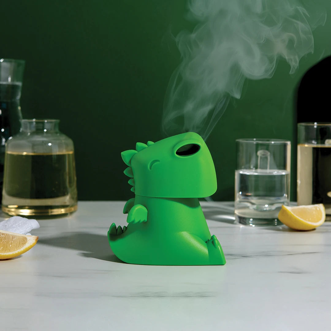 OTOTOs green Dracowave humidifier: dragon-shaped, emits vapor near glasses and lemon slices.