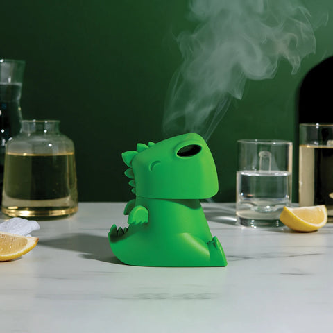 OTOTOs green Dracowave humidifier: dragon-shaped, emits vapor near glasses and lemon slices.