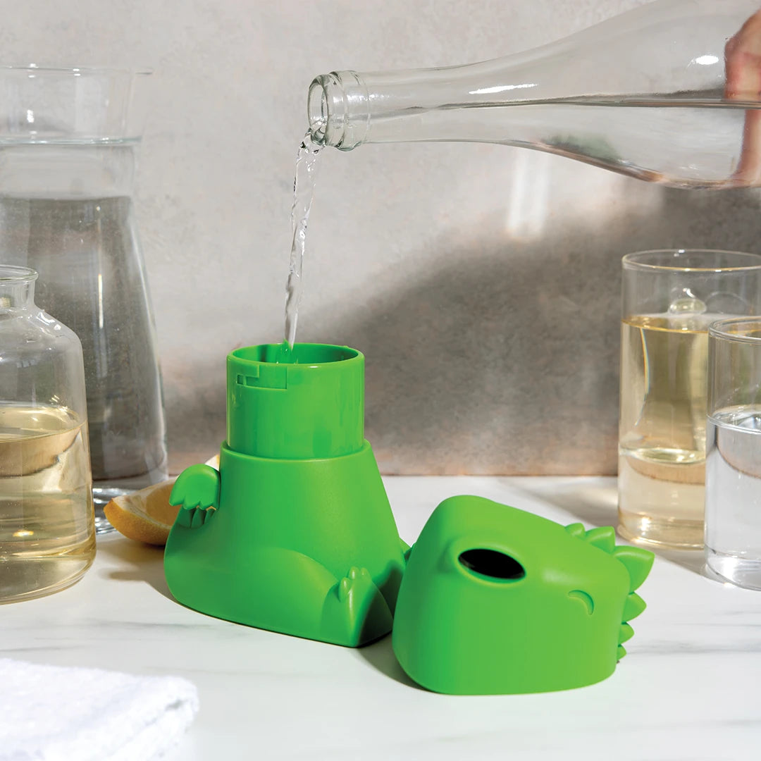 OTOTOs Dracowave humidifier, a green dinosaur shape, being filled on a bathroom counter.