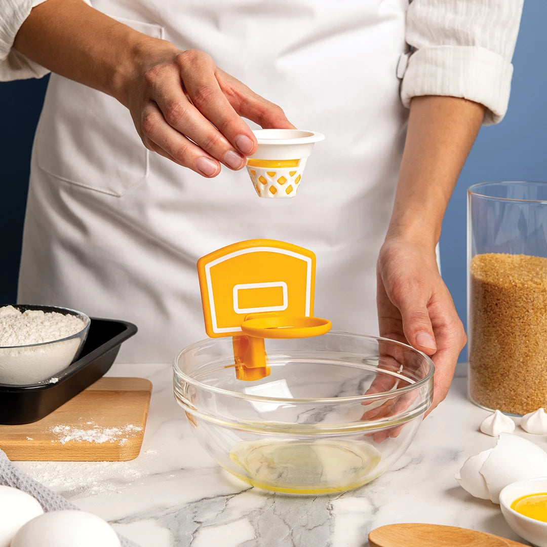 Person using the Dunk N Egg for separating eggs over a bowl.