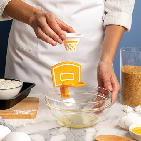 Person using the Dunk N Egg for separating eggs over a bowl.