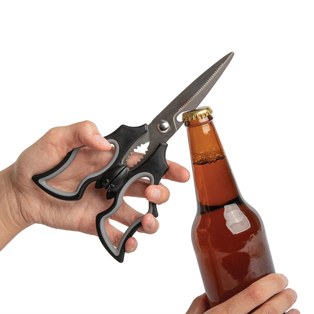 Hands using Elizabat kitchen scissors to open a beer bottle with a serrated edge.