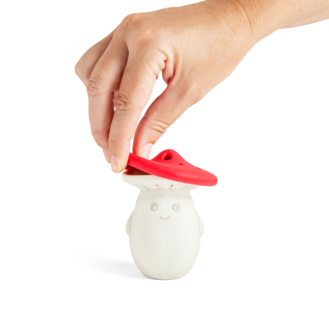 A hand lifts the Fun Guys red cap, revealing the smiling silicone steam releaser shaped like a mushroom.