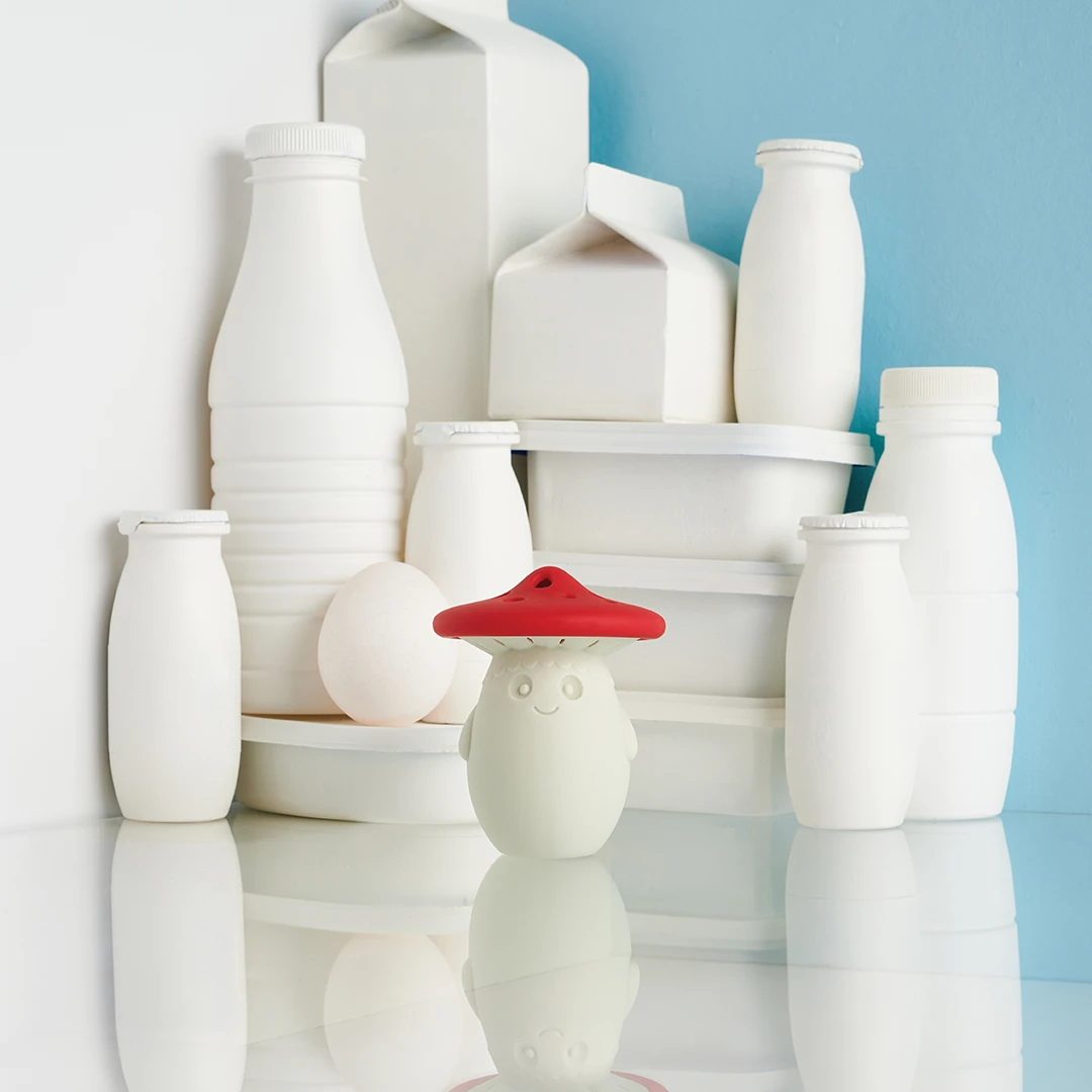 Fun Guy mushroom toy in white bottles and cartons reflects on a glossy surface.