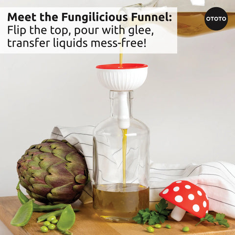 A Forest Trio red and white kitchen funnel pours oil into a glass bottle next to an artichoke.