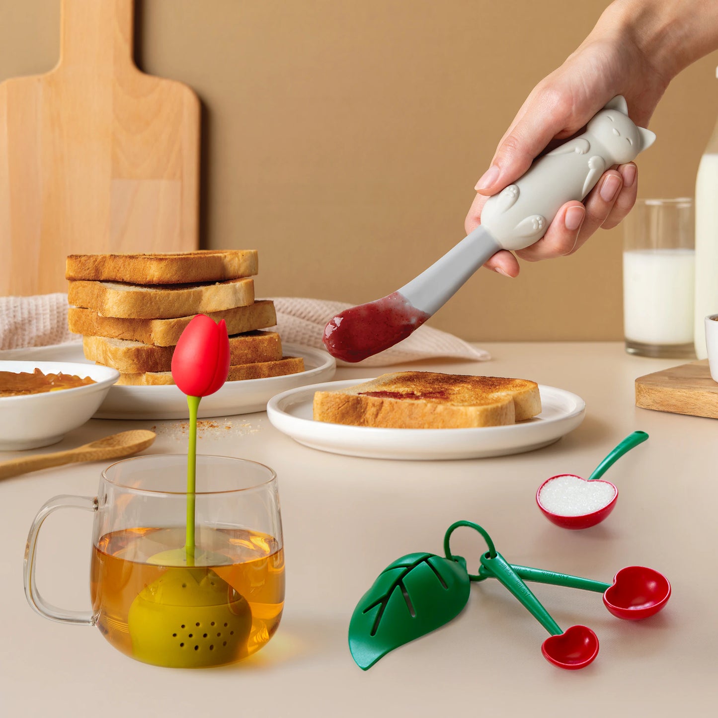 The Mary Cat spatula spreads jam beside a Tulip infuser and Mon Cherry leaf spoons.