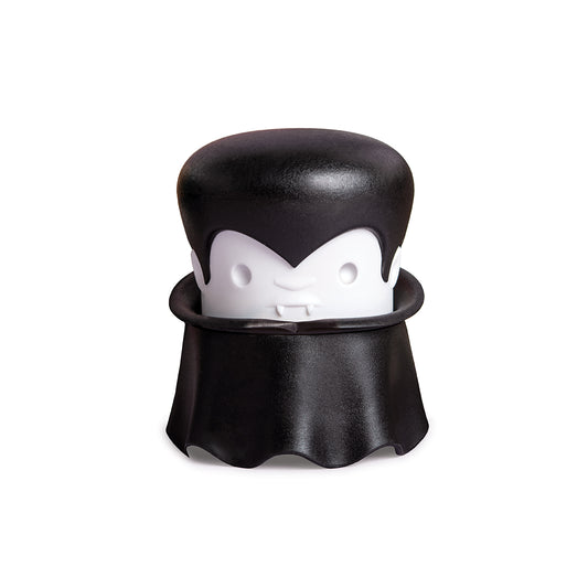 A cartoon vampire with a cape and fangs holds an OTOTO Gracula garlic crusher.