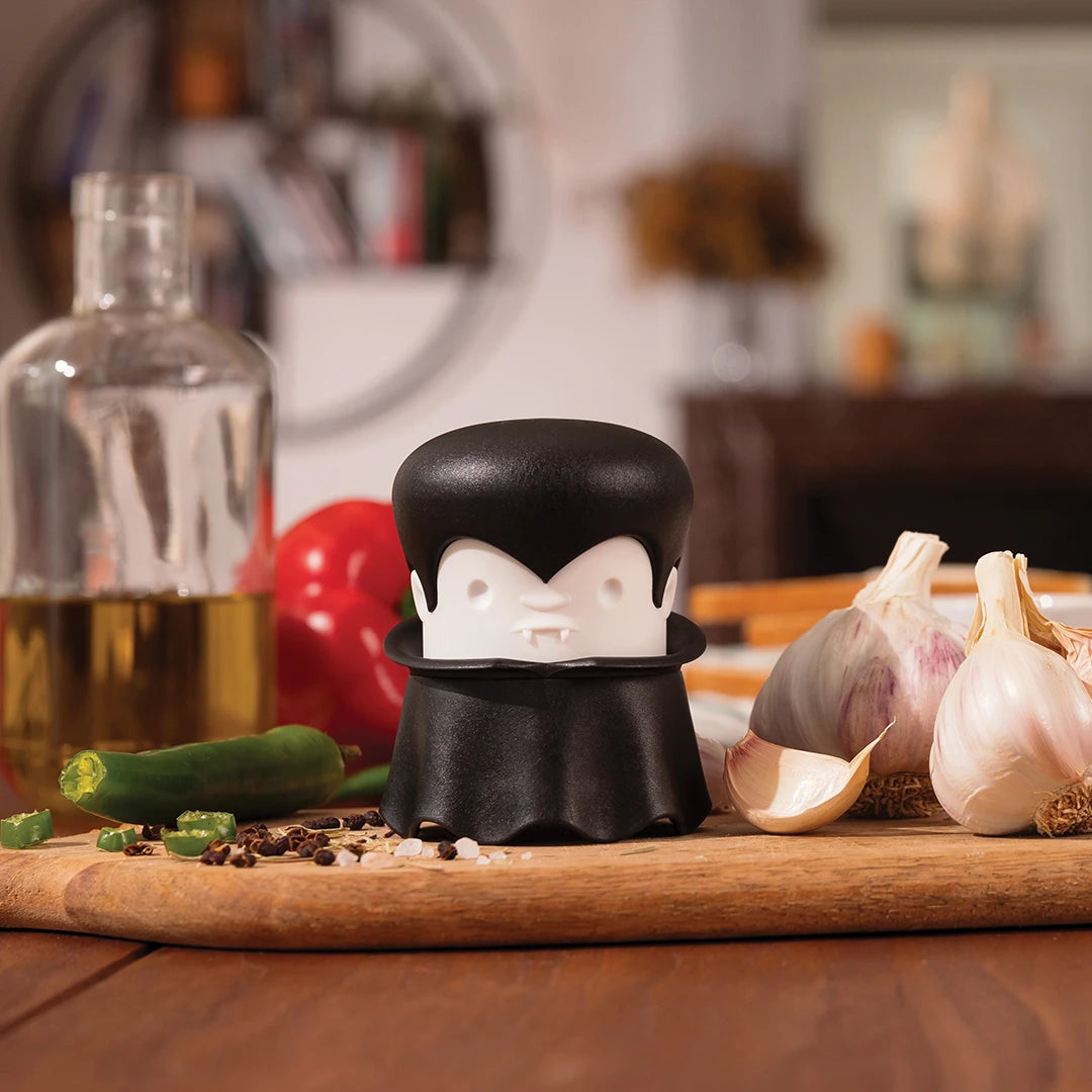 Gracula garlic crusher with bulbs and peppers on a kitchen counter by OTOTO.