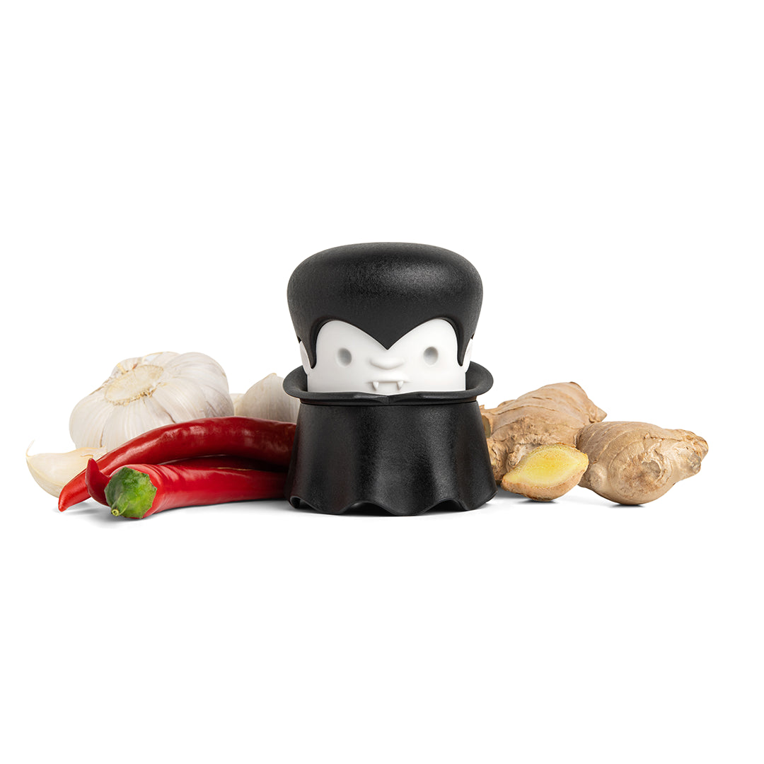 Gracula peeler with chili peppers and ginger on a white background.