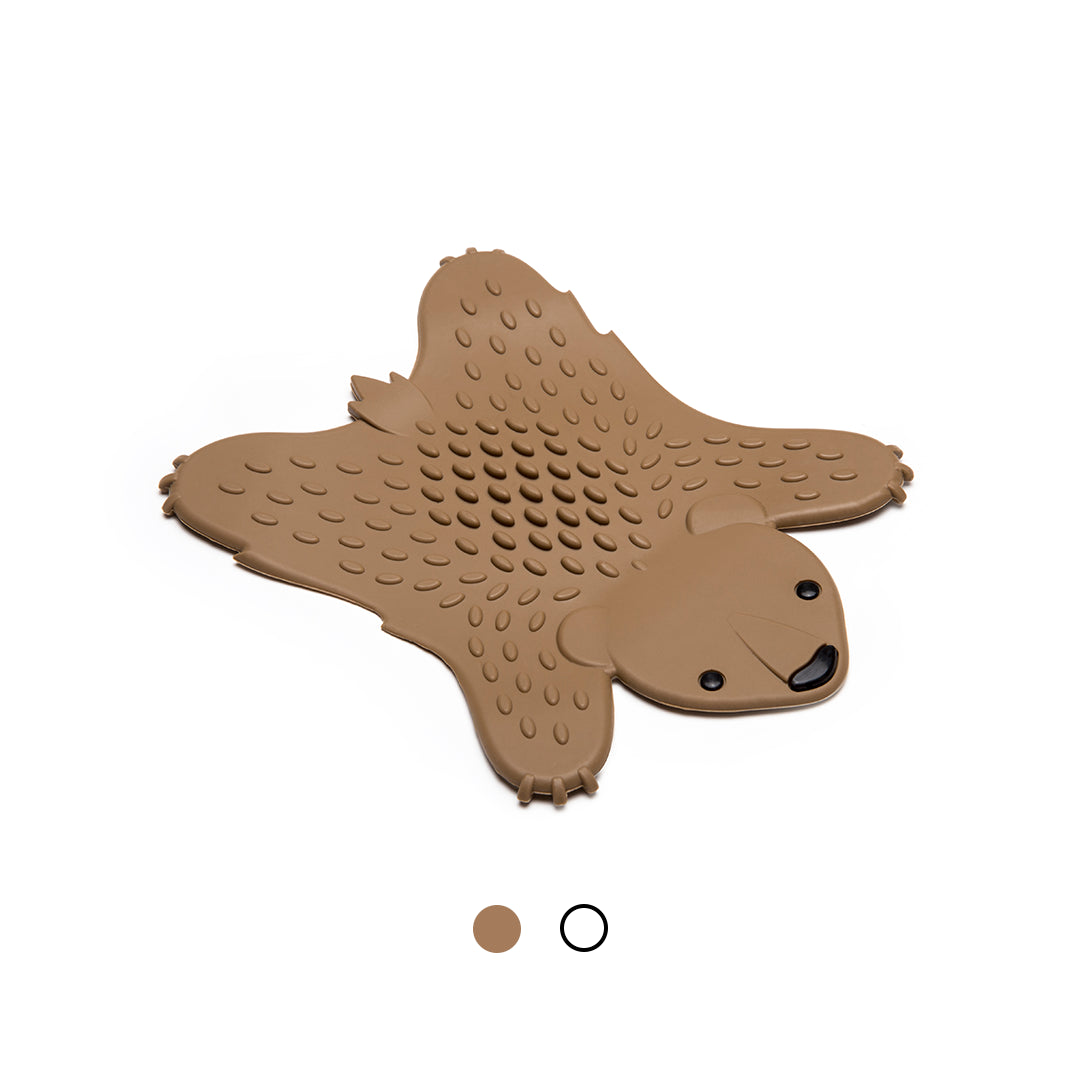 Grizzly bear-shaped silicone trivet with a textured surface on a white background.