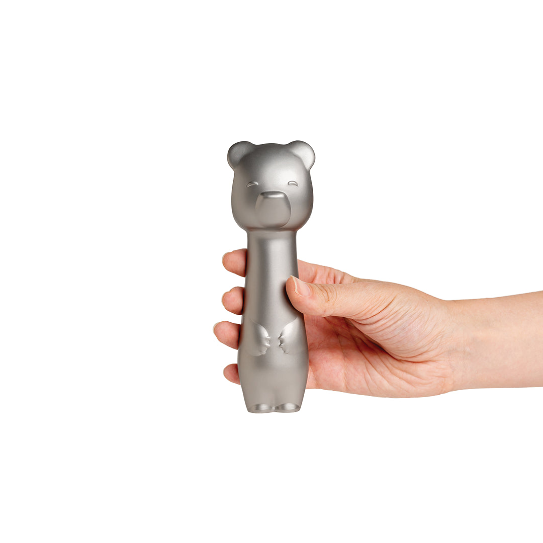 A hand holds the Big Dipper Ice Cream Scoop, a metallic bear-shaped tool by OTOTO, on white.