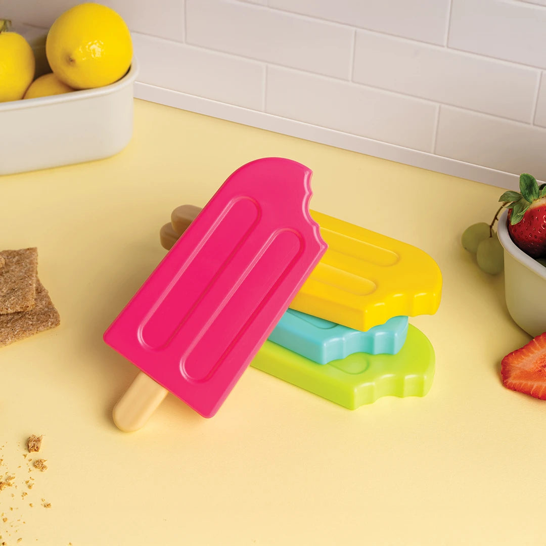 Three OTOTO Ice Pop Ice Packs stack neatly on a yellow counter near fruit and graham crackers.