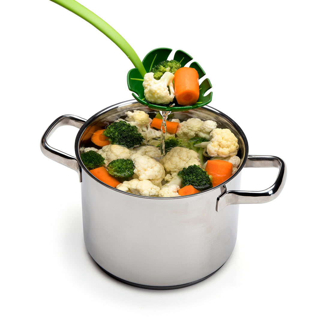 Vegetables drain with a leaf-shaped strainer attached to the pots edge, similar to a Jungle Spoon.
