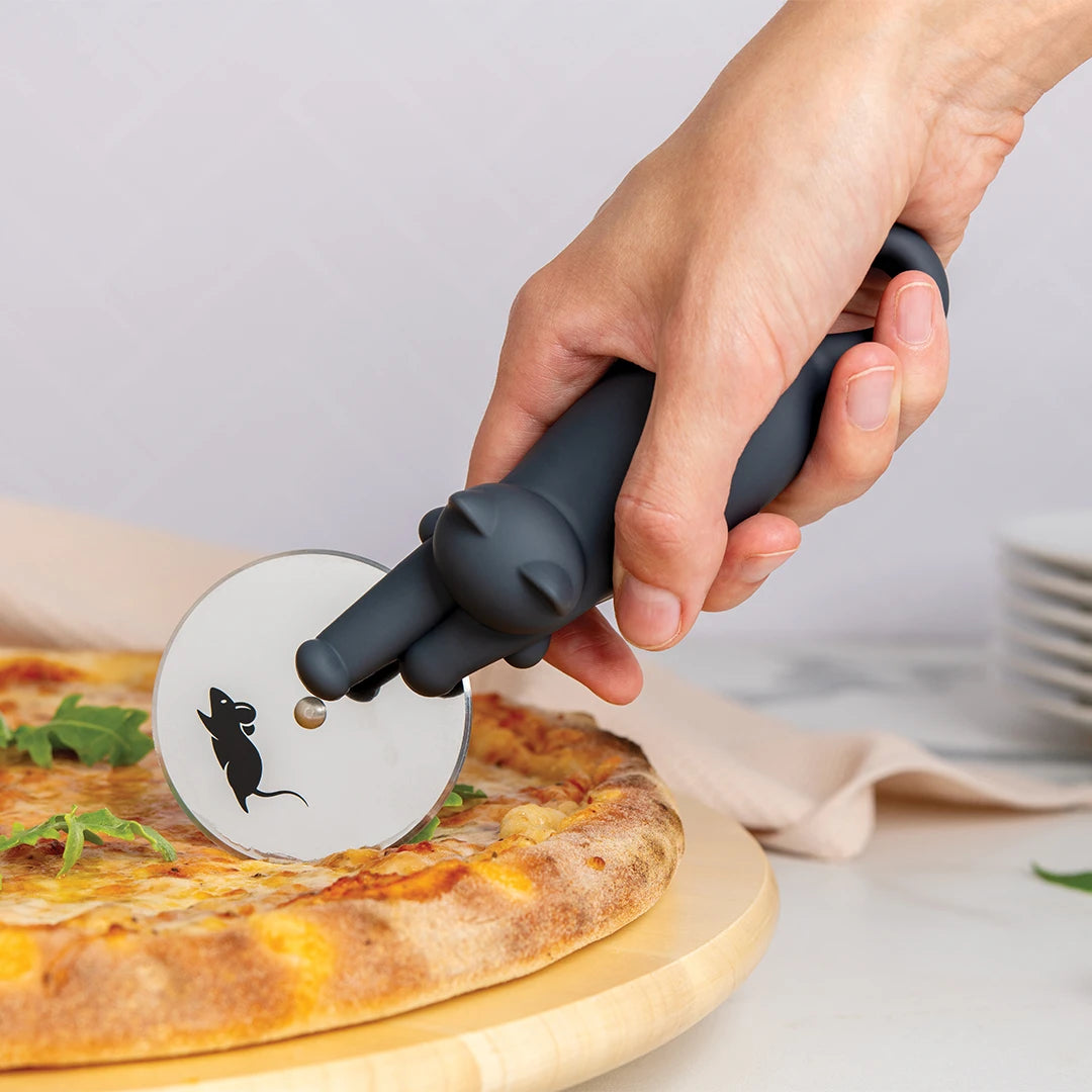 A hand uses the OTOTO Kitty-Cut, a cat-shaped pizza cutter with a mouse design, to slice a pizza.