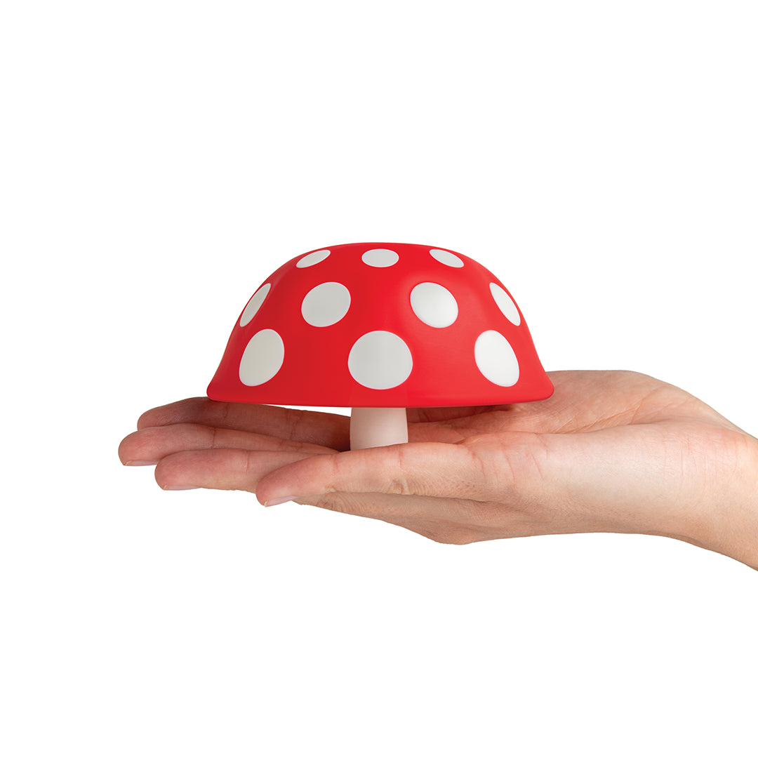 Hand holds a small, red Fungilicious XL with white spots on a white background.