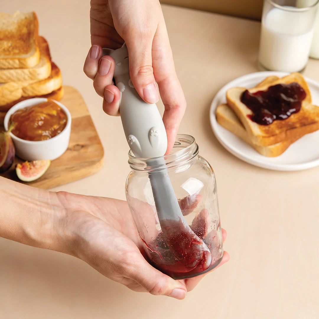 Person spreading jam on toast with an OTOTO Mary Cat gray spatula from a jar.