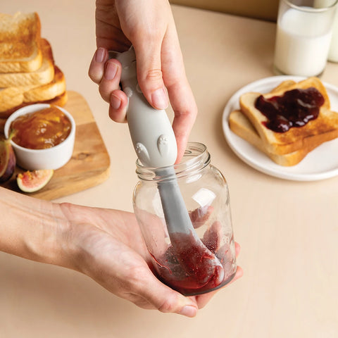 Person spreading jam on toast with an OTOTO Mary Cat gray spatula from a jar.