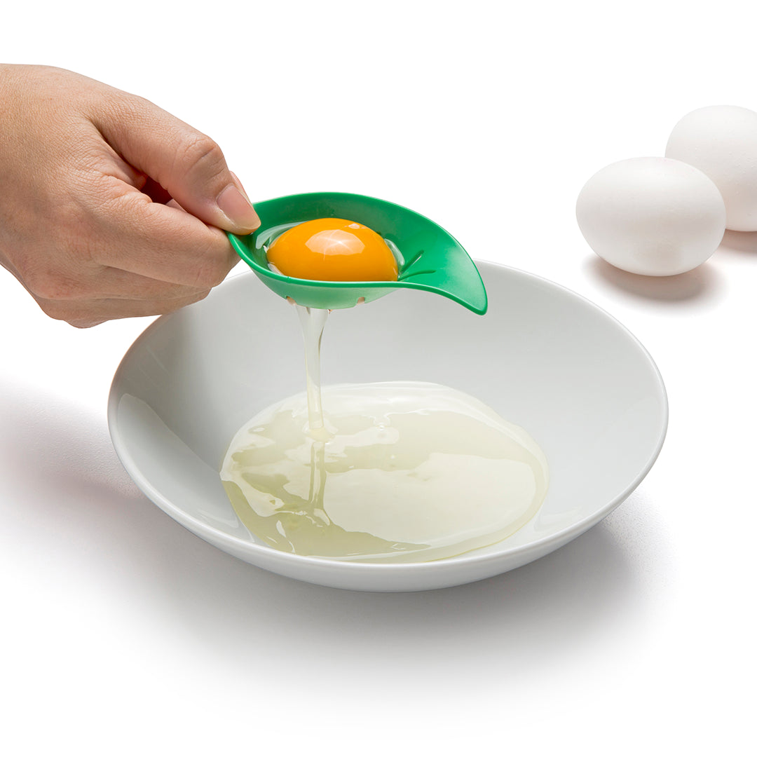 Someone uses the Mon Cherry egg separator to separate yolks over a bowl, ready for cooking & baking.