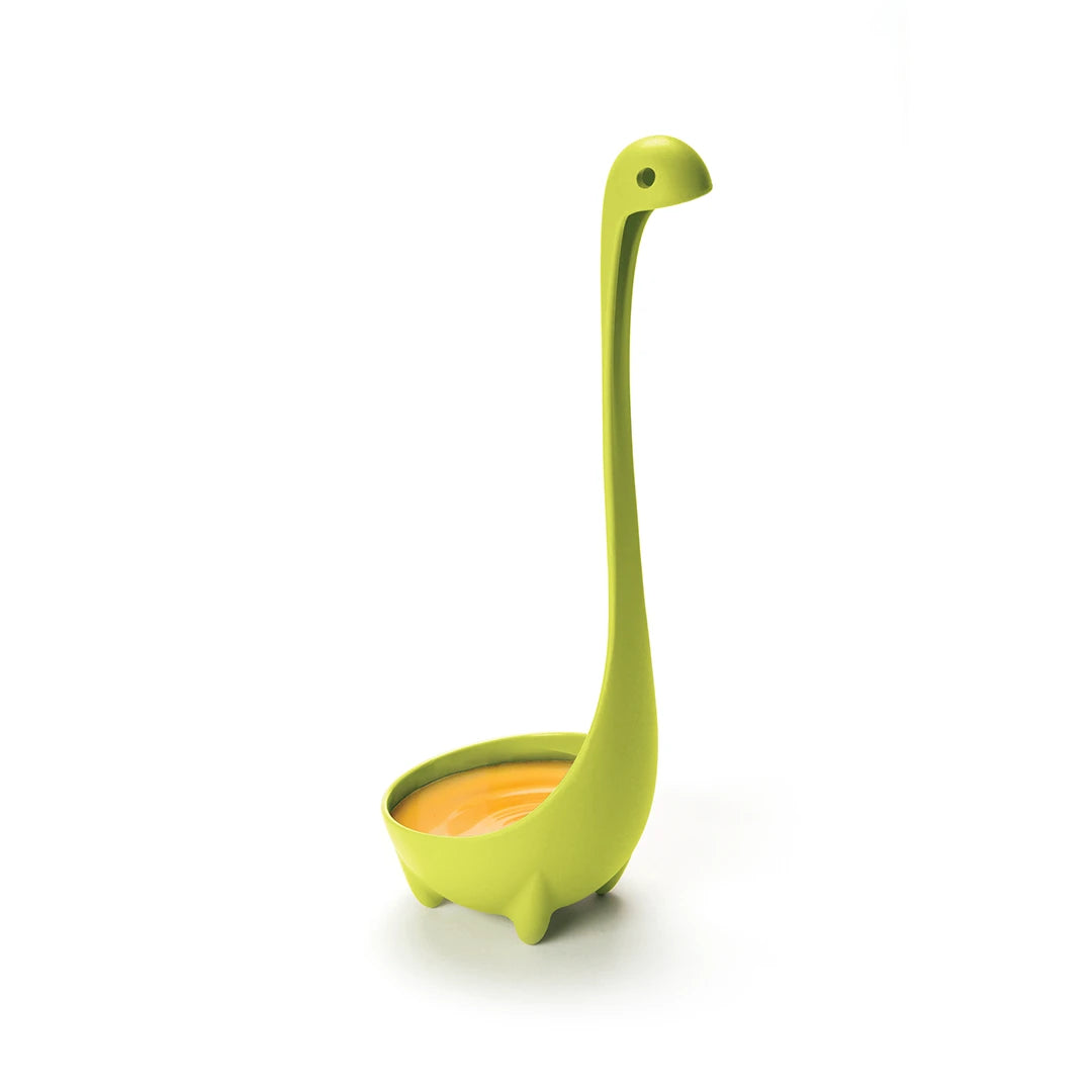 The Nessie ladle stands in orange liquid, resembling a green dinosaur.