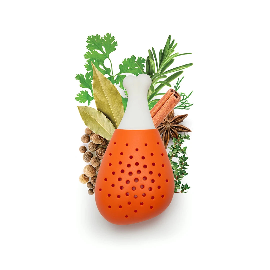 OTOTOs Pulke, an orange chicken-leg herb infuser, is surrounded by fresh herbs and spices.