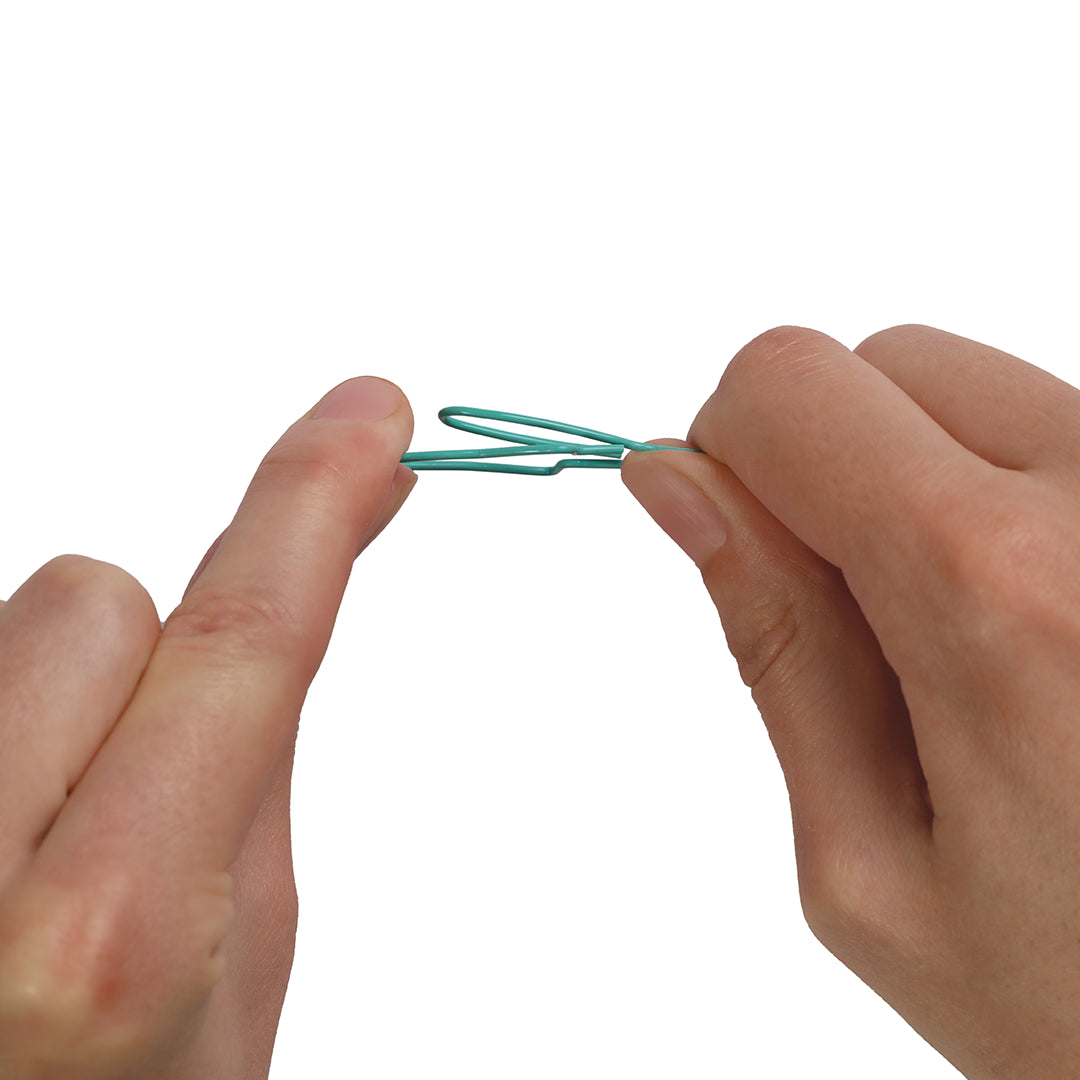 Hands holding a teal Sardine Paper Clip by OTOTO against a white background.