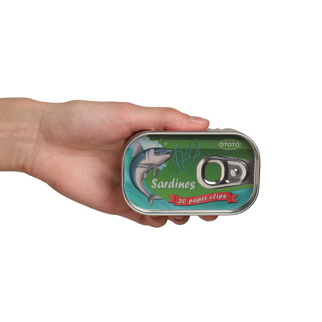 Hand holding OTOTO Sardine Paper Clips tin, with 30 fish-shaped clips and fish illustrations.