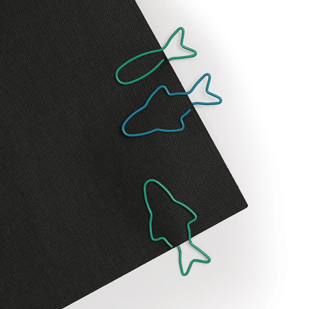 OTOTOs Sardine Paper Clips rest on a sleek black folder.