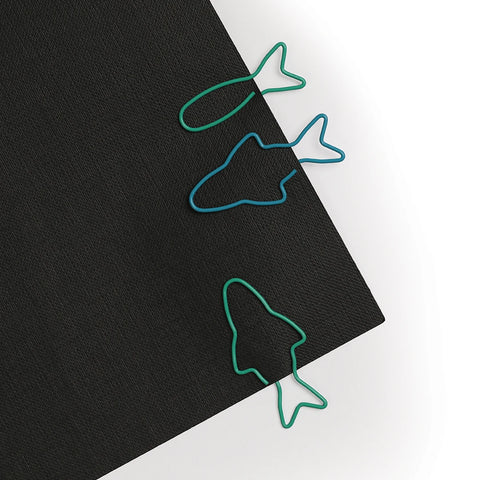 OTOTOs Sardine Paper Clips rest on a sleek black folder.