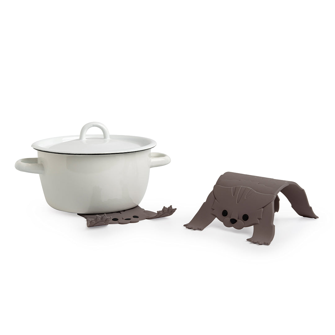 Pot with lid on Scaredy Cat silicone holder and another hot pot trivet beside it on a white background.