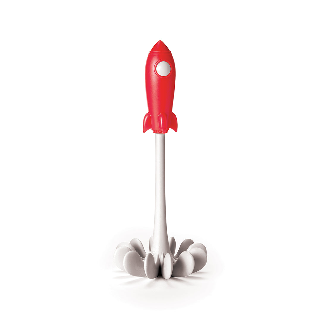The OTOTO Space Masher, a red rocket-shaped toilet brush, stands upright in its white flower-like holder.