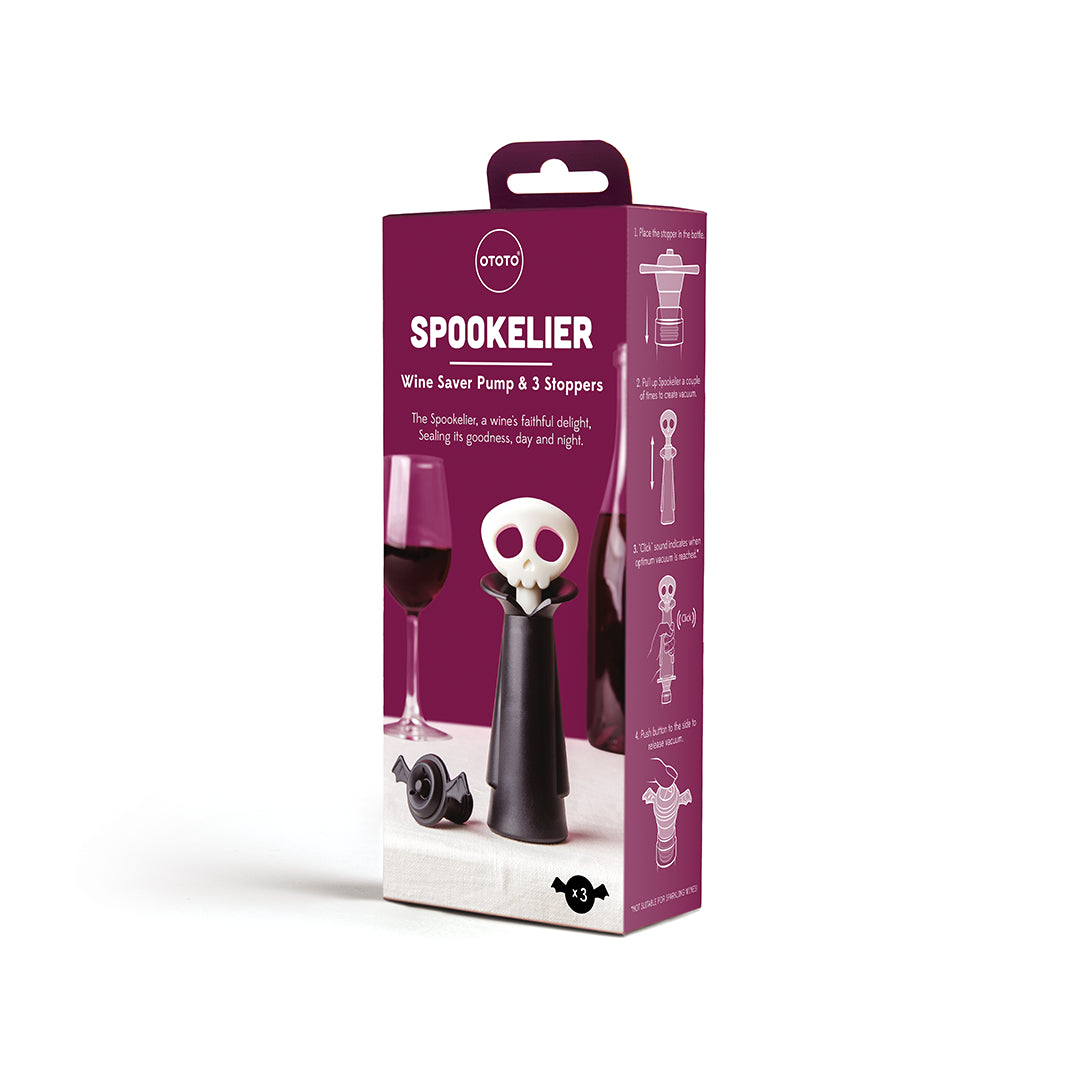 Spookelier wine saver in a purple box with vampire design next to red wine glasses.