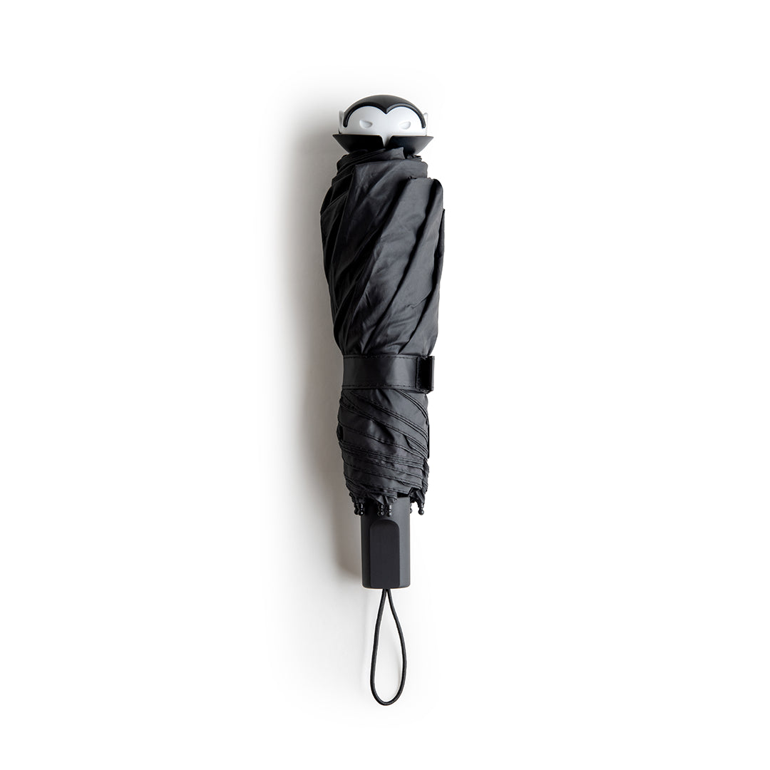 Stylish Spookula umbrella by OTOTO, features a penguin handle and wrist strap, on a white background.
