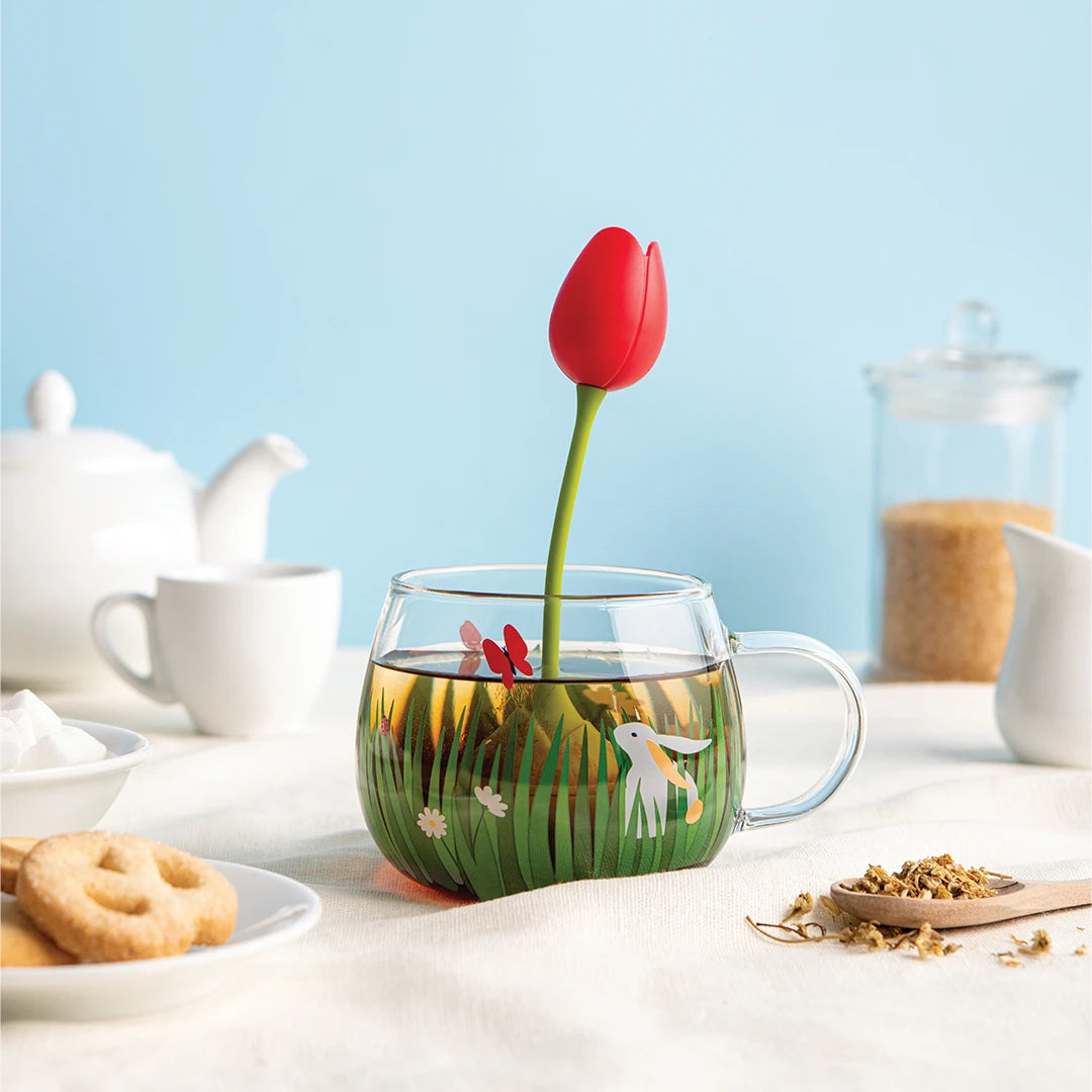 Tea Garden cup with floral design, OTOTOs red tulip tea infuser, and cookies on a table.
