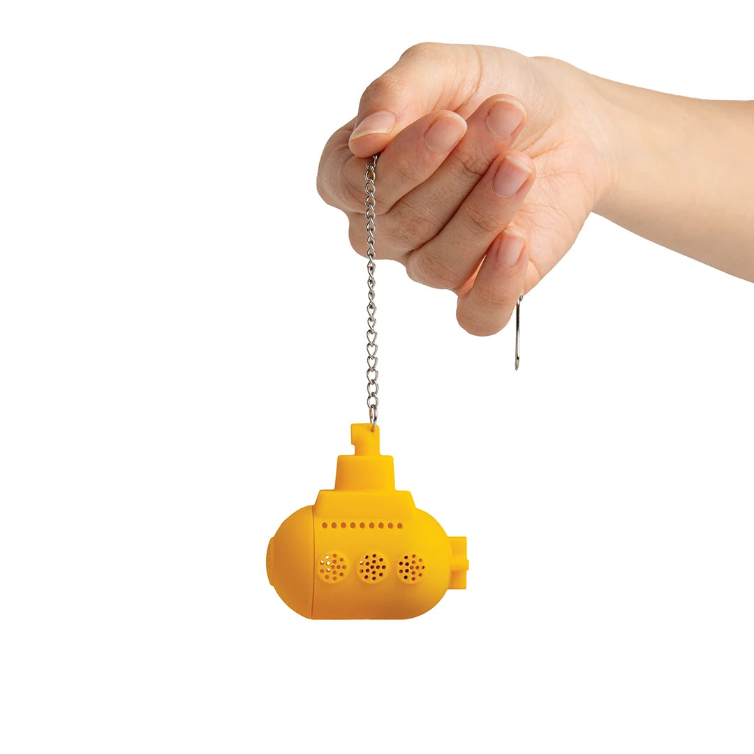 Hand holding a Tea Sub, a small yellow submarine-shaped infuser with a metal chain.