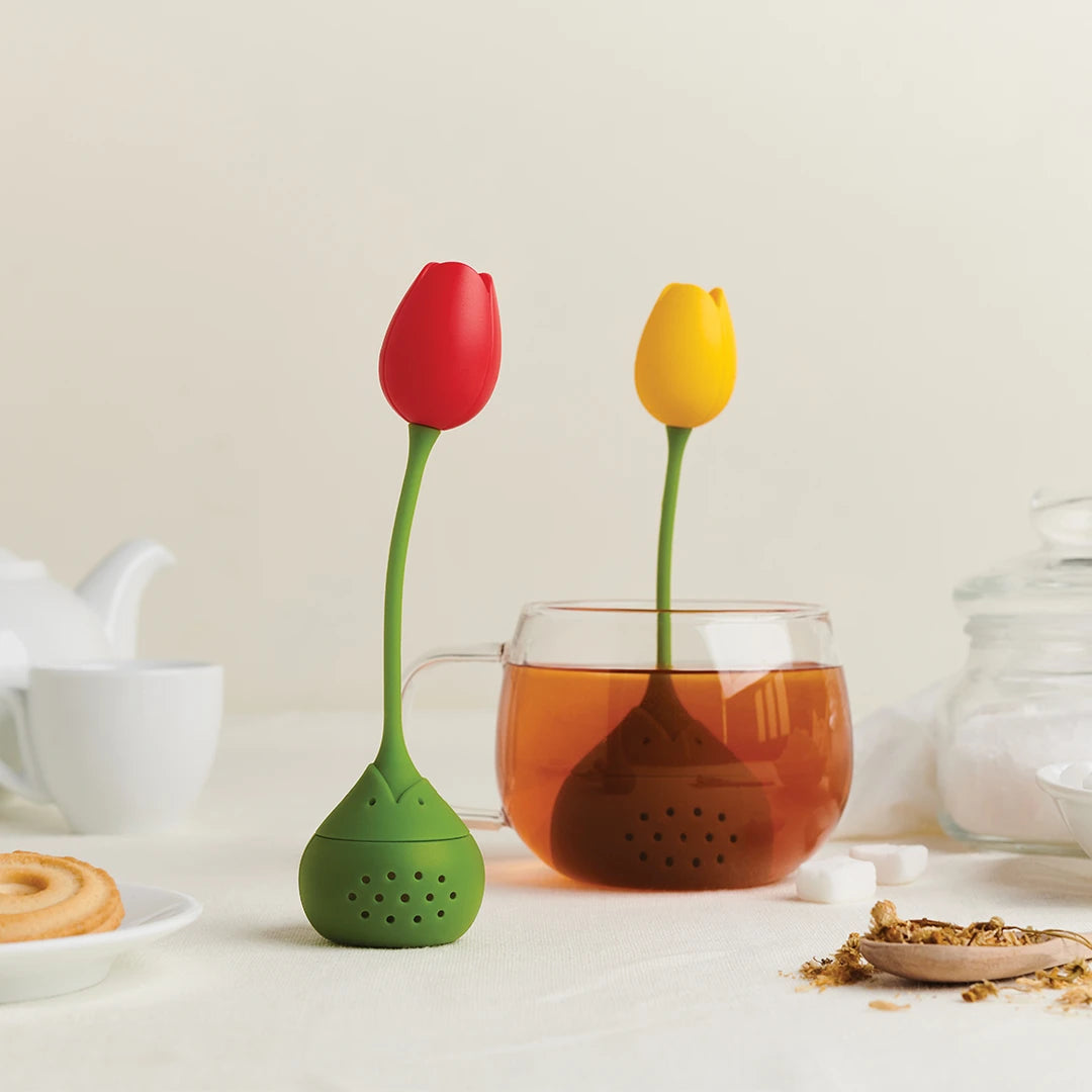 Tulip infusers by OTOTO in red/yellow in a glass with cookies and scents on the table.