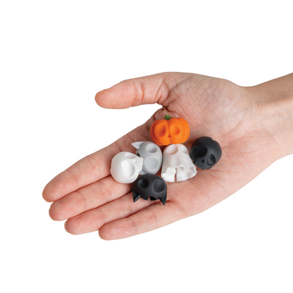 A hand holding Boo Team Halloween figurines: a pumpkin, skulls, ghosts, and a black cat.
