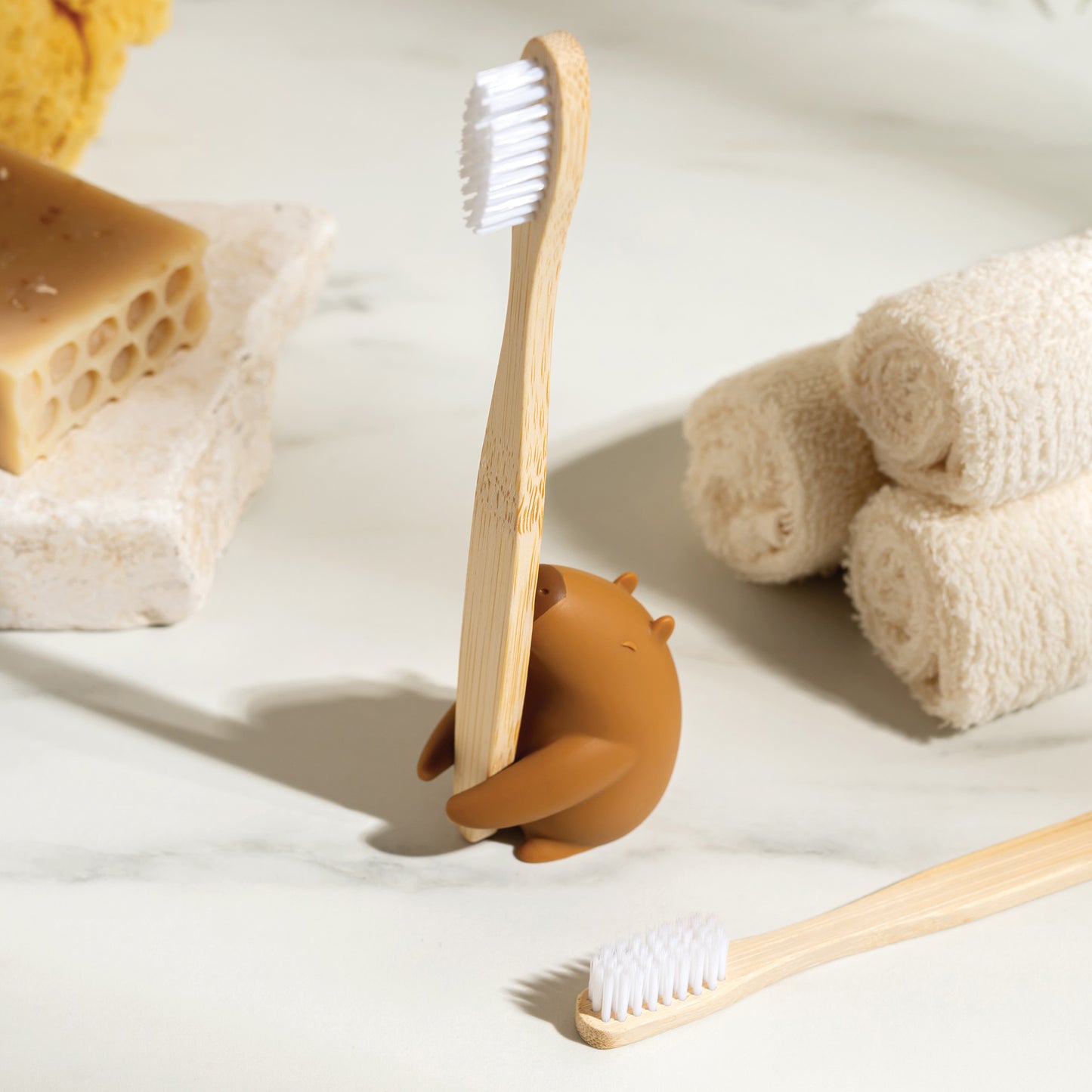 Capybrush holds a bamboo toothbrush, with towels and soap close at hand.