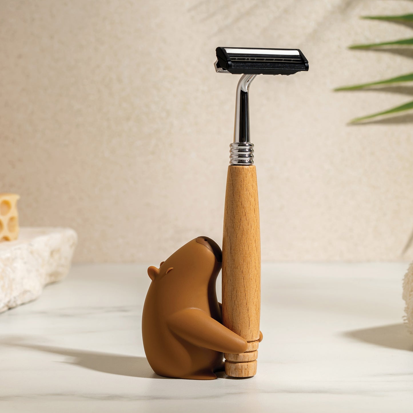 OTOTO’s Capybrush holds a wooden-handled razor on a light countertop.