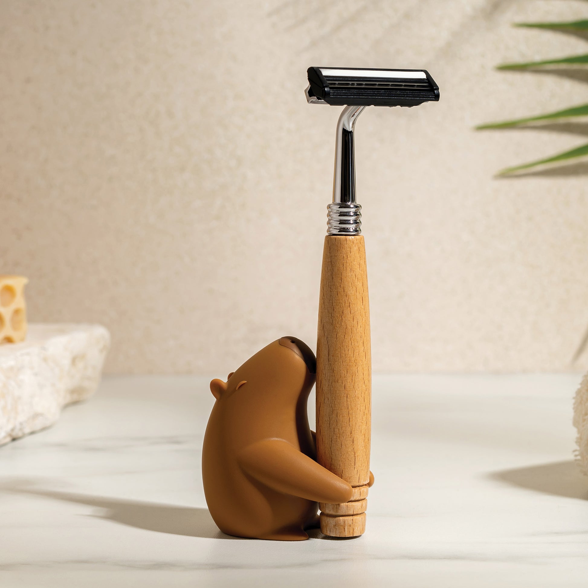 OTOTO’s Capybrush holds a wooden-handled razor on a light countertop.