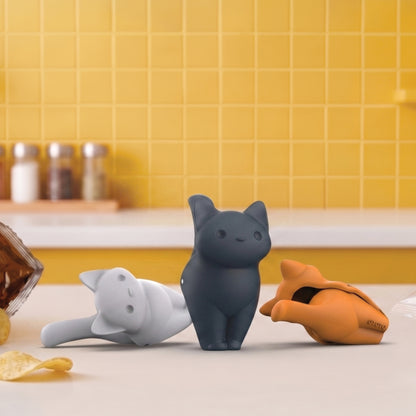 Three CatSnap bag sealers—gray, black, and orange—are on the counter beside a snack bag.